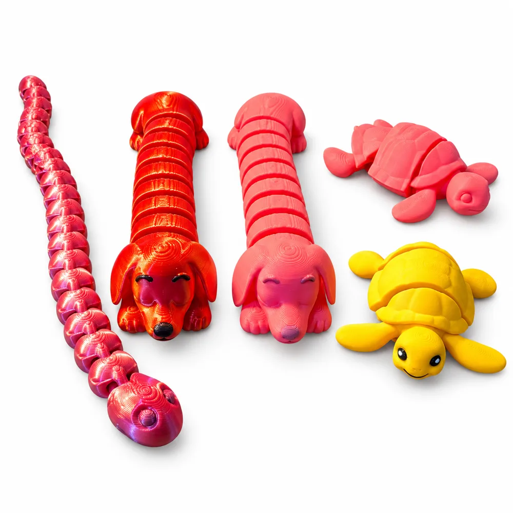 3D printed flexi animals in red, pink and yellow