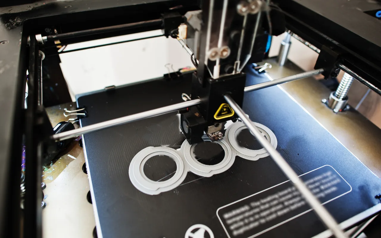 A 3D printer building round parts on the bed