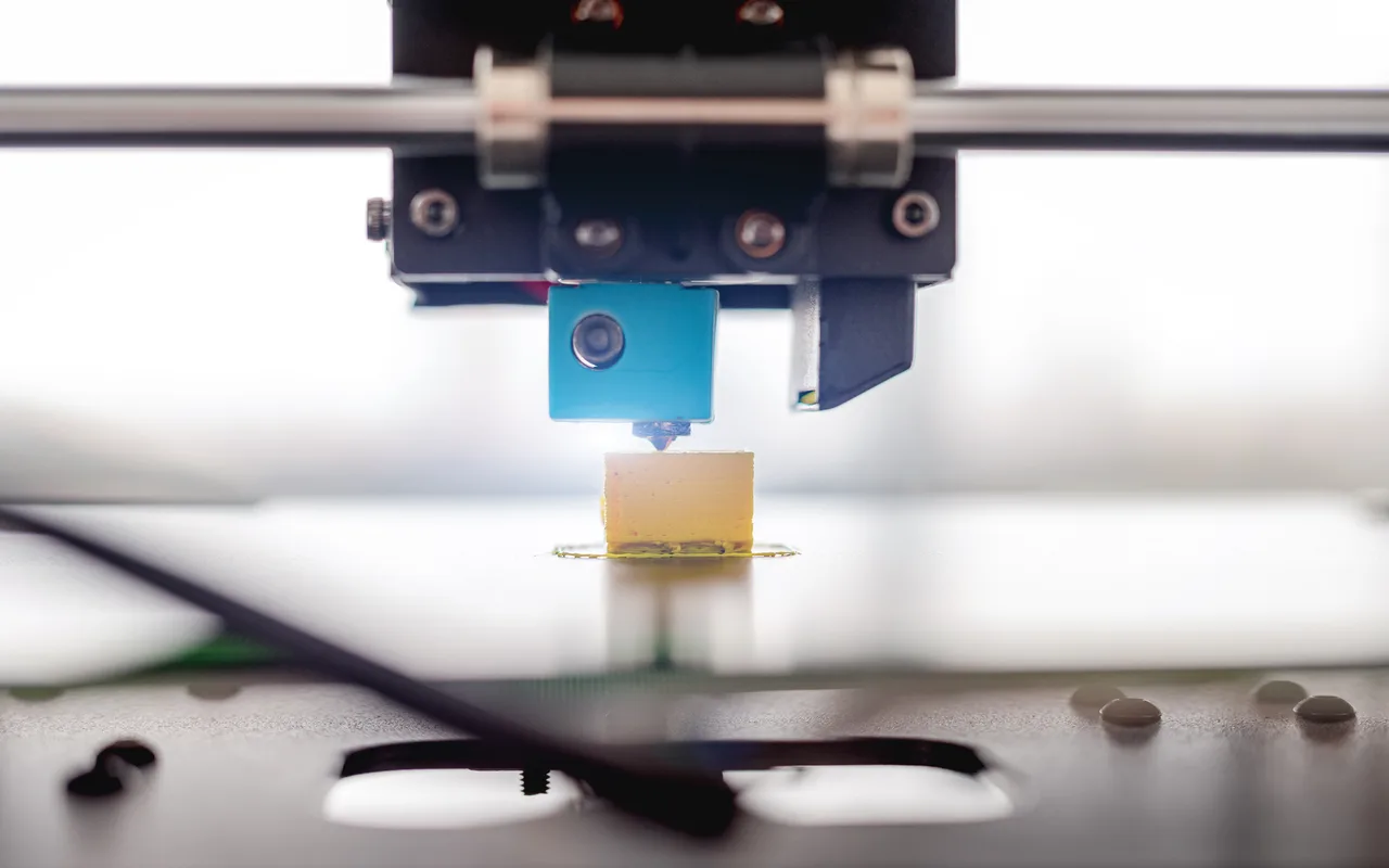 Close up of a 3D printer hotend printing a small part